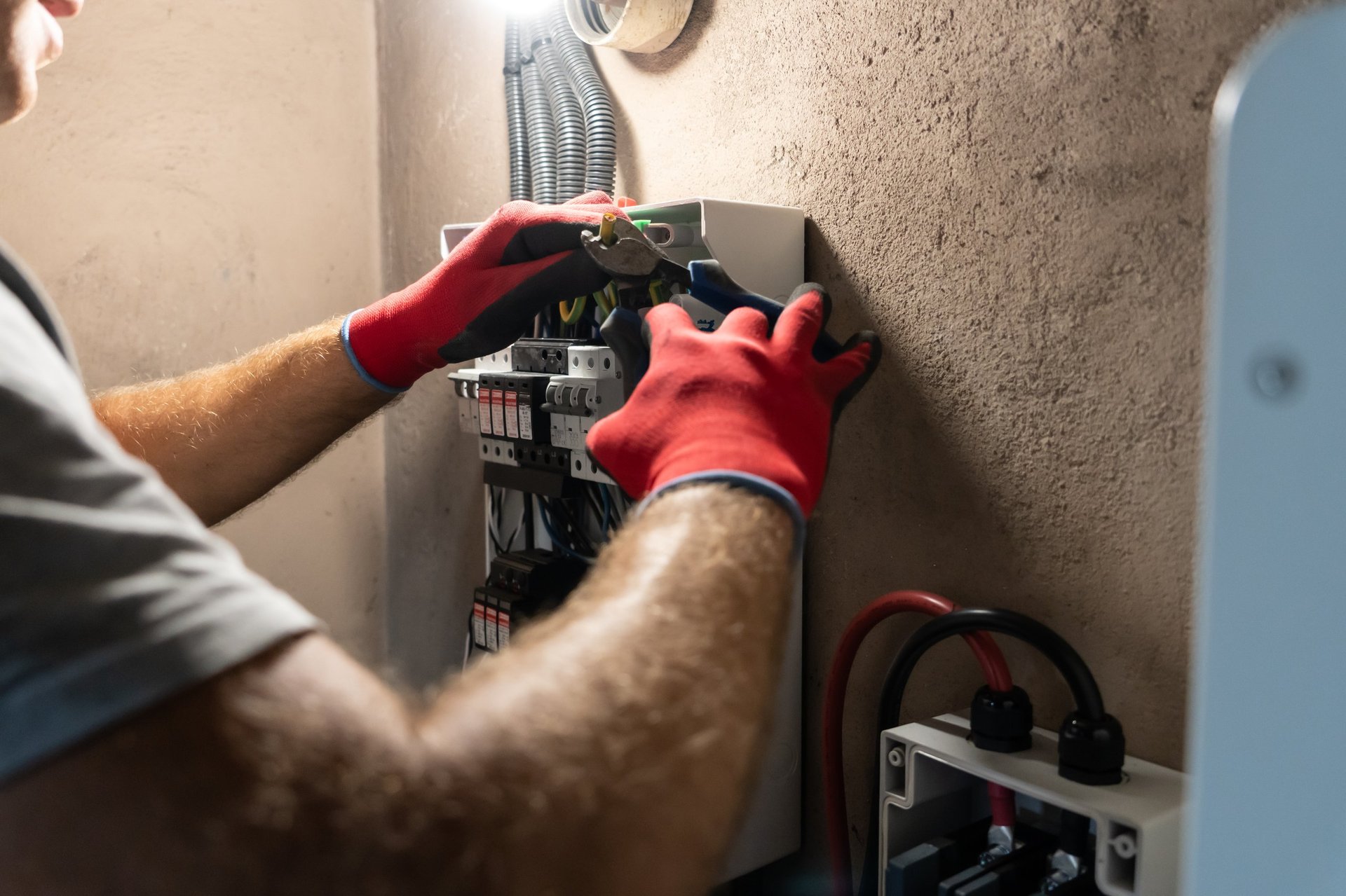 Electrician performing installation work inside an electrical panel