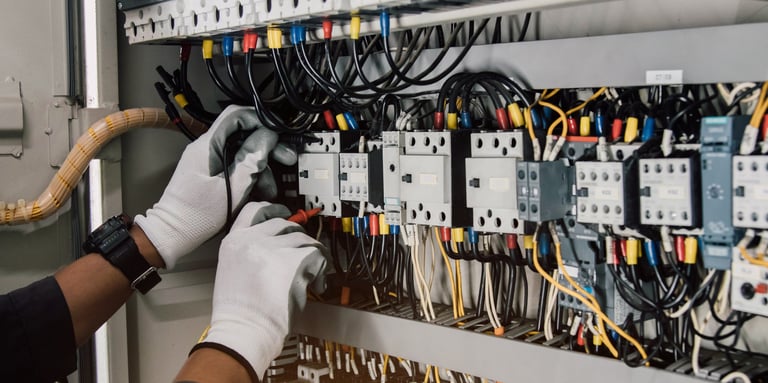Electrician testing electrical installations and wiring on a relay protection system